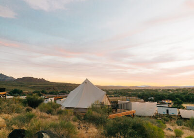 Luxury camping tent in desert at sunset.