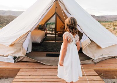 Child entering luxurious glamping tent outdoors.