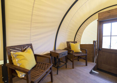 Cozy wooden cabin interior with chairs and cushions.