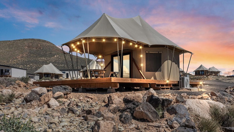 Luxury tented camp at twilight in rocky desert landscape