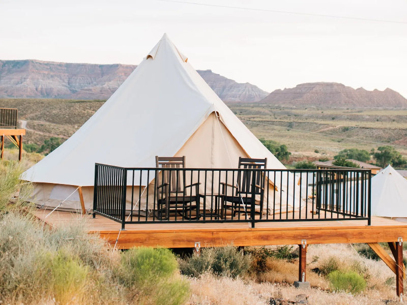 Glamping tent with patio in desert scenery.